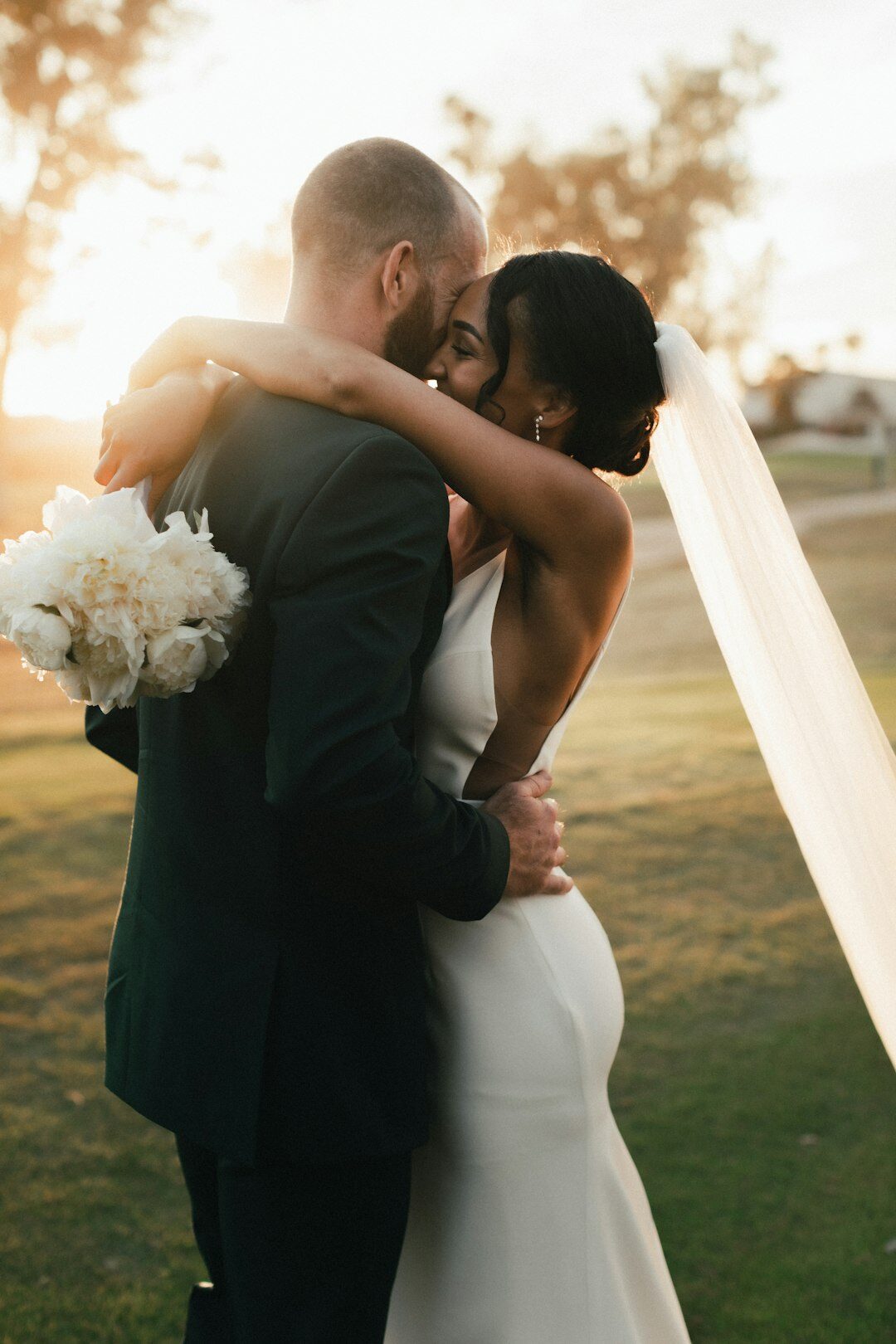 Bride and groom embracing during golden hour