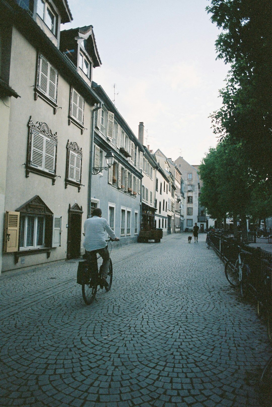 Cyclist riding through a cobblestone street in an old European city