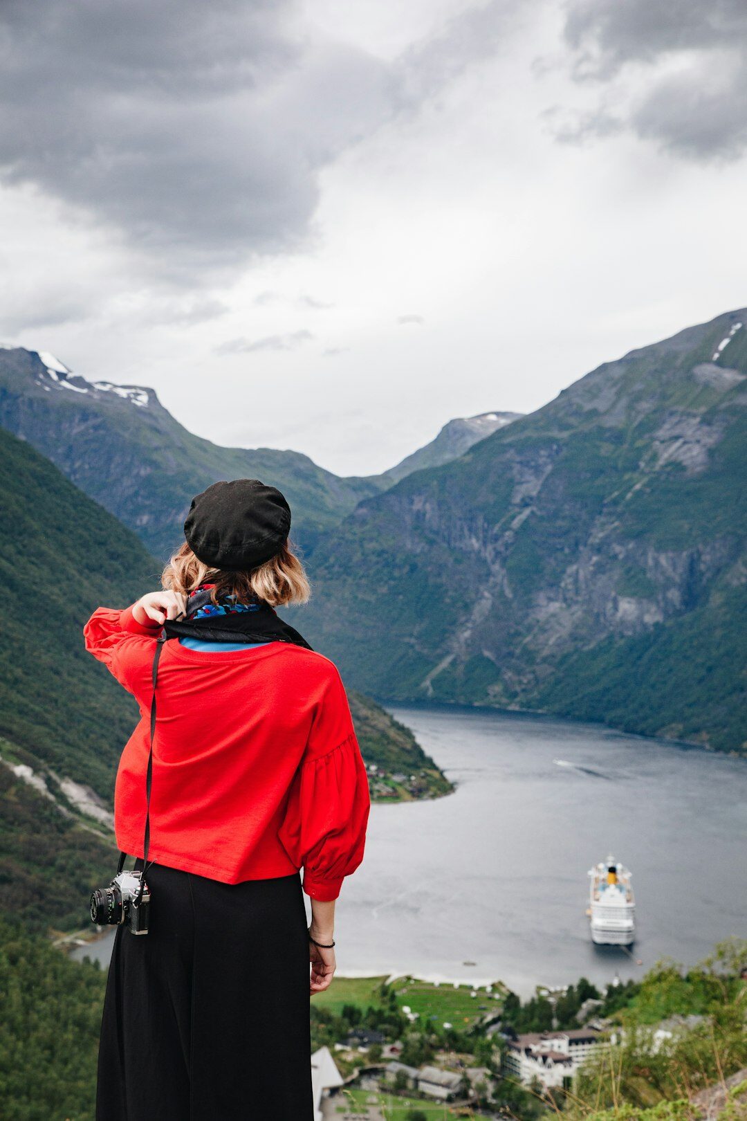 Traveler with backpack looking out over a fjord
